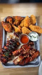 A promotional video for The Dial in North Greenwich, featuring shots of the venue's interior, bar area, and a selection of their sharing-style food menu including a meat platter, wagyu burger, and chicken schnitzel.
