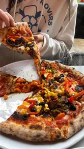 A short, montage-style video showcasing a visit to Pizza Punks, featuring shots of the venue's neon signage, pizza boxes, cocktails, and close-ups of pizzas being sliced and dipped into a gravy sauce.
