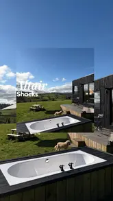 A montage video showcasing a family's stay at a cabin in North Wales, highlighting the scenic views, outdoor bath, and cozy interior, followed by a meal at a local pub.