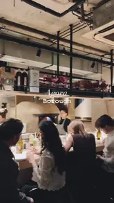 A fast-paced, visually appealing reel showcasing a variety of dishes and drinks at Agora in Borough, London. The video features close-up shots of dipping bread into various spreads, skewers, pork belly, and a dessert, interspersed with glimpses of the lively, open-kitchen atmosphere.