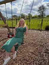 A lifestyle photograph featuring a woman on a swing in a playground area at an estate, intended to showcase the family-friendly facilities of the venue.