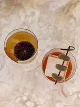 An overhead shot of two cocktails served on a marble surface, showcasing the presentation of the drinks.