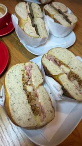 A short, punchy showcase of various bagel sandwiches at a cafe, featuring close-up shots of the food and the menu board.