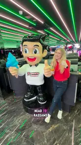 A group of friends visits Rassams Creamery in Manchester, highlighting the futuristic neon decor, robot waiters, and a variety of indulgent desserts including syrup sponge, waffles, and pancakes.