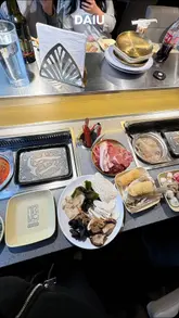 A review of DAIU, an all-you-can-eat BBQ and hot pot restaurant in the UK. The video takes the viewer through the buffet selection, including various meats, seafood, vegetables, and cooked items like sushi and tempura, followed by the cooking process at the table and a look at the dessert and drink options.