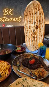 A montage showcasing various dishes and drinks at BK Restaurant, including a mix grill, karahi, naan, and various beverages.