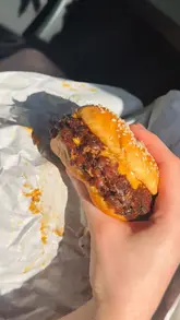 A vlog-style review of a new smash burger venue in Liverpool, featuring the creator visiting the shop, showcasing the menu items including burgers, sides, and milkshakes, and highlighting the available merchandise.