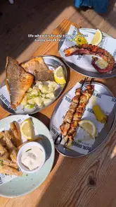 A short, energetic video showcasing a variety of Greek dishes at The Real Greek, including grilled seafood, souvlaki, and desserts, while highlighting the bright, airy venue with views of cherry blossoms.