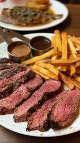 A video review of Bordelaise in Tooting Market, featuring a variety of French bistro dishes including steak, plaice meunière, scallops, and tarte tatin, alongside shots of the cozy, mural-decorated interior.