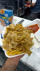 A creator reviews a local takeaway shop in Wibsey, Bradford, showcasing their pizza, donner meat and chips, and cheeseburger.