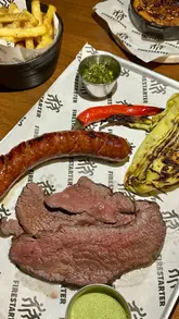 A review of the 'Ruben's Reubens' pop-up at Firestarter Grill, showcasing the 'build your own grill tray' concept, including various meats, sides, and the cooking process.