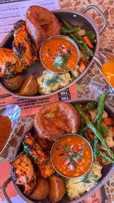 A promotional video showcasing an Indian-inspired Sunday roast at Tuk Tuk in Edinburgh. The video features close-up shots of the food, including chicken tikka, Yorkshire puddings, and various gravies, followed by shots of the restaurant's interior and exterior.