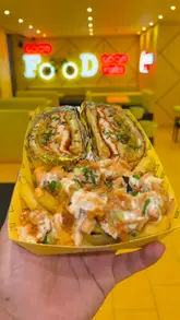 A food review video featuring a creator trying various fusion dishes like butter chicken pizza and parmo toasties at Mr T's.
