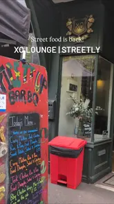 A short video showcasing a Caribbean street food pop-up at XO Lounge in Streetly. The video features a menu board and close-up shots of various dishes being served into takeaway containers, including jerk chicken, curry mutton, and sides.