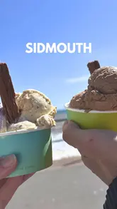 This reel follows a couple and their baby on a day trip to Sidmouth, Devon. It highlights a coffee stop at The Pea Green Boat, a scenic walk through Connaught Gardens and Jacob's Ladder, and a visit to The Fort for ice cream. The video uses a vlog-style format with upbeat music and text overlays to guide the viewer through the itinerary.