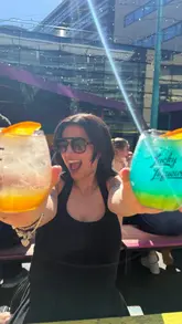 The video features a creator visiting Edinburgh Street Food on a sunny day. It highlights the outdoor seating area, various spritz cocktails, and specific food items like chicken tenders and waffle fries, encouraging viewers to visit during the summer.