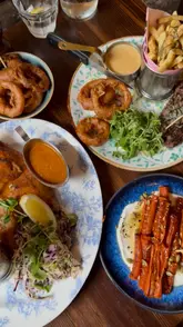 A montage of food and drinks at Bill's restaurant, featuring starters, mains, and desserts, along with a screen recording of their menu.