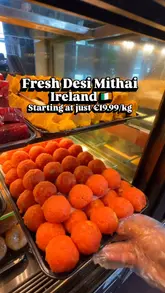A short, handheld video showcasing a variety of fresh Indian sweets (mithai) being selected and boxed at Sarvanaa Bhavan in Dublin.