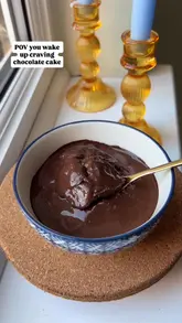 A short, instructional video demonstrating how to prepare a single-serving chocolate cake in a bowl using protein powder and simple ingredients, presented as a quick breakfast or dessert option.