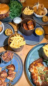 A group of friends enjoying a bottomless brunch at Nyla's in Leeds, featuring cocktails, pub-style food, and a lively atmosphere with a DJ.