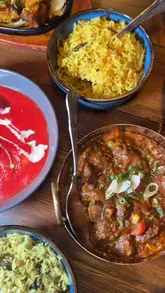 A montage-style video showcasing a variety of Indian dishes and the interior of Cafe Spice in Newcastle. The video features close-ups of curries, starters, and sizzlers, along with shots of the restaurant's seating area, highlighting the dining experience.