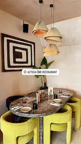 A promotional reel for Azteca Öme featuring a variety of Mexican dishes, including tacos, quesadillas, and churros, alongside a cocktail preparation sequence. The video highlights the venue's interior and the 'bottomless' dining experience.
