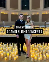 A photo of a couple posing in front of a stage filled with candles at a Candlelight Concert event.