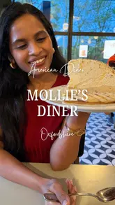 Here are a few options for your SEO alt text, depending on what is in the specific photo:

**Option 1 (Focus on the vibe):**
An authentic American-style diner interior with red booths at Mollie’s Motels in Oxfordshire.

**Option 2 (If it’s a food shot):**
A table full of American diner comfort food, including burgers and shakes, at Mollie’s Diner in Oxfordshire.

**Option 3 (If it’s the exterior/drive-thru):**
The exterior of Mollie’s Diner in Oxfordshire featuring their convenient American-style drive-thru lane.

**Best Practice Tip:** Keep it descriptive of exactly what the user sees in that specific frame so it remains accessible and SEO-friendly.