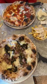A review of Pizza on the Park in Bristol, featuring the creator trying various dishes including garlic pizza bread, arancini, and two different pizzas, along with fries and white wine. The video highlights the restaurant's interior and the quality of the pizza dough.