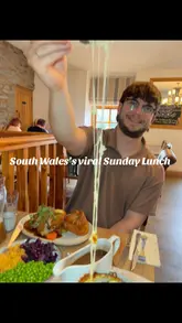 A couple visits Bistro 8 to review their Sunday lunch. The video features close-up shots of the roast dinner, including gravy being poured, a cheese pull on the cauliflower cheese, chicken wings, onion rings, and desserts. The atmosphere is cozy and the food is presented in an appealing way.