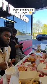A casual, vlog-style video featuring two friends reviewing a fast-food restaurant called Hennys in Blackburn. The video captures the ordering process at a kiosk, the interior of the venue, and a variety of menu items including burgers, wings, loaded fries, milkshakes, and brownies. The tone is lighthearted and humorous, focusing on the friends' interaction while eating.