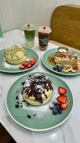 A short, polished video showcasing Japanese soufflé pancakes, milk cakes, and boba drinks at Sipping Boba. The video features slow-motion shots of the food being served and drizzled with sauce, set to music with minimal text overlays.