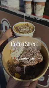 A short review video featuring a visit to Cocoa Street, a street food van. The video showcases several dessert items including a brownie crumble pot, a chocolate San Sebastian cheesecake, and a karak chai, with close-up shots of the food and the menu.