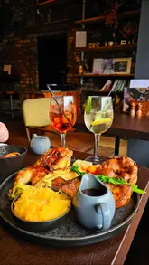 A promotional reel for Brewstone in Uplands, Swansea, featuring their Sunday roast menu, including roast chicken, beef brisket, and sticky toffee pudding, alongside cocktails and the venue's interior.