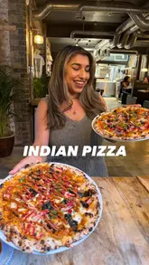 A short, punchy reel showcasing a variety of Indian-fusion pizzas and starters at East West Pizza. The video features close-up shots of the food, including cheese pulls and texture details, presented by the creator.
