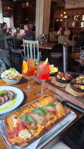 The video features a creator visiting 'Head of Steam' to try their new menu, including Detroit-style pizza, small plates, and cocktails. It also highlights the venue's interactive darts and shuffleboard games, providing a comprehensive look at the experience.