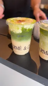 The video provides a brief tour of KRMÉ & Co., starting with the exterior and moving inside to show the menu board and the preparation of various matcha-based drinks. It concludes with a shot of the finished product.