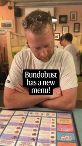 A couple visits Bundobust to review their new menu, showcasing a wide variety of vegetarian Indian street food dishes and craft beer. The video features close-ups of the food, the menu, and the creators enjoying the meal in a casual, friendly atmosphere.