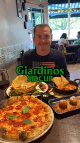 A video review of Giardinos Pizzeria in Sidcup, featuring a variety of Italian dishes including pizza, arancini, prawns with chorizo, wild boar tortellini served in a garlic bread bowl, tiramisu, and Nutella dough balls.