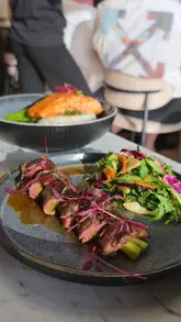 A review of 10Ten Bar & Bistro on Heaton Road, showcasing a selection of small plates, a salmon main, and a sticky toffee pudding dessert. The video features a voiceover describing the meal and the venue's atmosphere.
