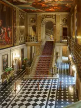 A high-quality, well-composed photograph of the grand staircase and painted ceiling inside Chatsworth House. The image captures the opulent, historic architecture with clear lighting and sharp detail, effectively showcasing the venue's grandeur.