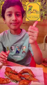 A young creator visits Chit 'n' Chaat, an Indian street food restaurant, reviewing a variety of dishes including dosa, prawns, noodles, curry, naan, and fish pakora. The video uses a fast-paced, vlog-style edit to highlight the food and the venue's colourful, lively atmosphere.