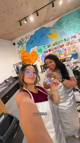 The video features two creators visiting a glass-making workshop in London, where they learn to make glass flowers. It documents the entire process, from putting on safety gear and selecting glass rods to melting and shaping the glass, highlighting the beginner-friendly nature of the activity.