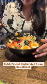 A video review of Momoya restaurant in Dublin, featuring a variety of Asian dishes including chicken karaage, prawn tempura, bang bang chicken noodles, kimchi fried rice, and tofu ramen, alongside cocktails and a kunafa cheesecake dessert.