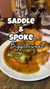 A review of a Sunday roast experience at Saddle & Spoke, featuring beef and chicken roasts, cauliflower cheese, cocktails, and dessert.
