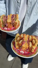 The video features a food influencer reviewing the menu at 'Chunky Buddha,' a food popup currently operating out of the 'Ringside' bar and kitchen in London. The creator highlights several dishes, including a steak sando, a Szechuan hot honey chicken sandwich, duck noodles, and beef bulgogi mac and cheese, providing commentary on the flavors and textures while showing the preparation process and the final product.