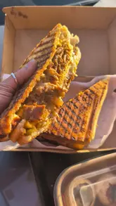 A short, fast-paced video showcasing various street food items from Lahori Lane, a drive-thru venue in Manchester. The video features close-up shots of noodles, a sandwich, pani puri, and a dessert, highlighting the variety available.