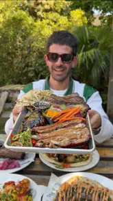 A high-energy food review video featuring a creator visiting 'The Dragon Flame' at The Heathcote and Star in London. The video showcases various BBQ dishes, including rotisserie pork, beef brisket, pork ribs, and steak, with close-up shots of the food being prepared and eaten. The creator provides enthusiastic commentary on the quality of the meat, positioning the venue as a top BBQ spot.