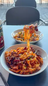 A short, energetic video showcasing a casual pasta restaurant located at the Albert Dock. The reel features close-up shots of fresh pasta dishes, arancini, and cheesy garlic bread, interspersed with views of the waterfront setting. The editing is fast-paced, highlighting the 'build your own' concept and the appetizing nature of the food.