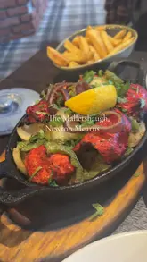 A review-style video showcasing a visit to The Malletsheugh in Newton Mearns. The creator highlights the fusion of Indian and Scottish cuisine, showing various dishes including halloumi, chicken tikka, and chocolate fudge cake. The video includes shots of the venue's interior, the extensive menu, and the dining experience.